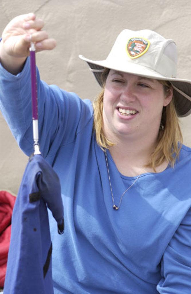 Karen Munroe weighs a round-tailed ground squirrel